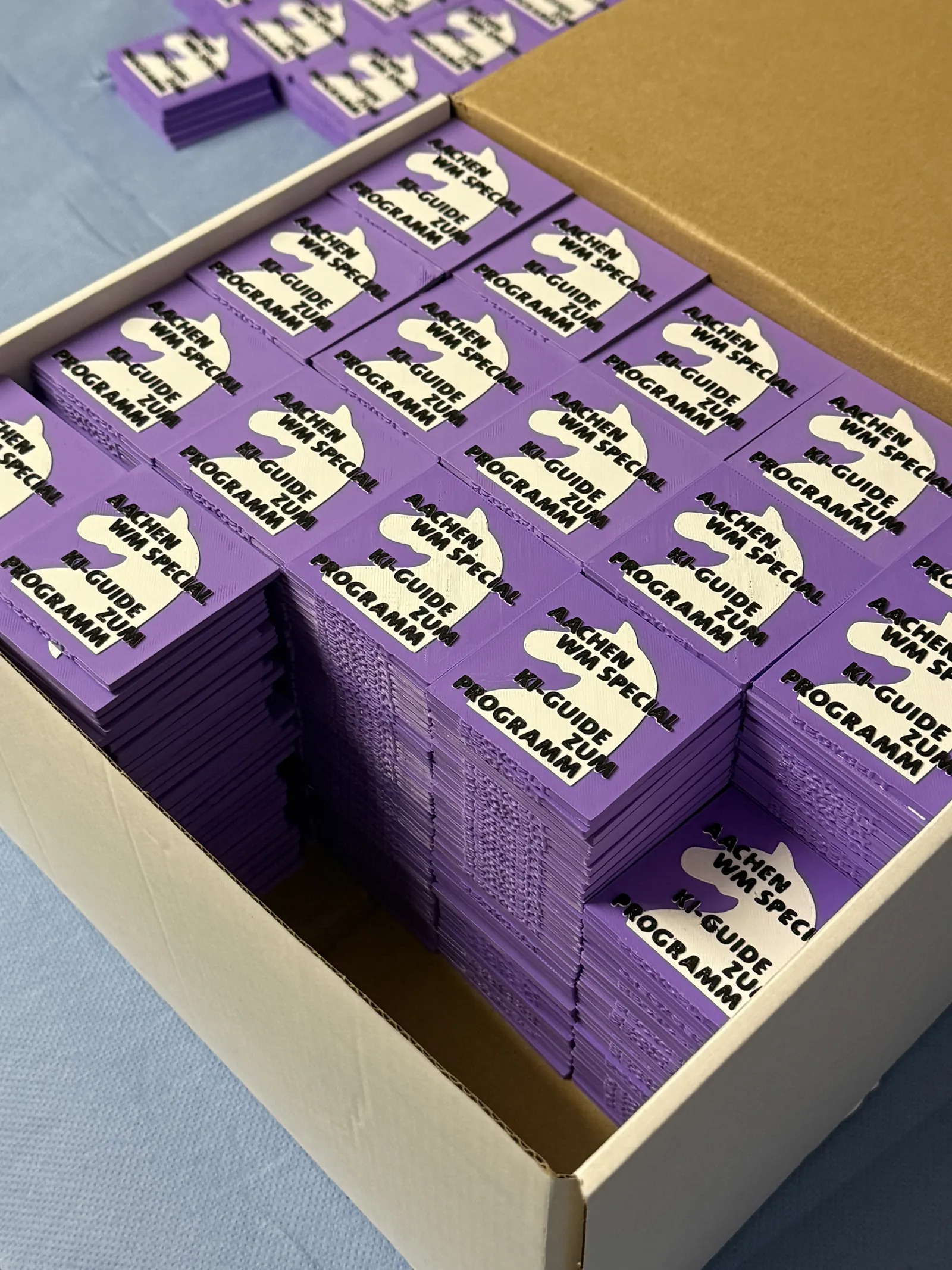 Geöffnete Schachtel mit zahlreichen gestapelten violetten Programm-Chips